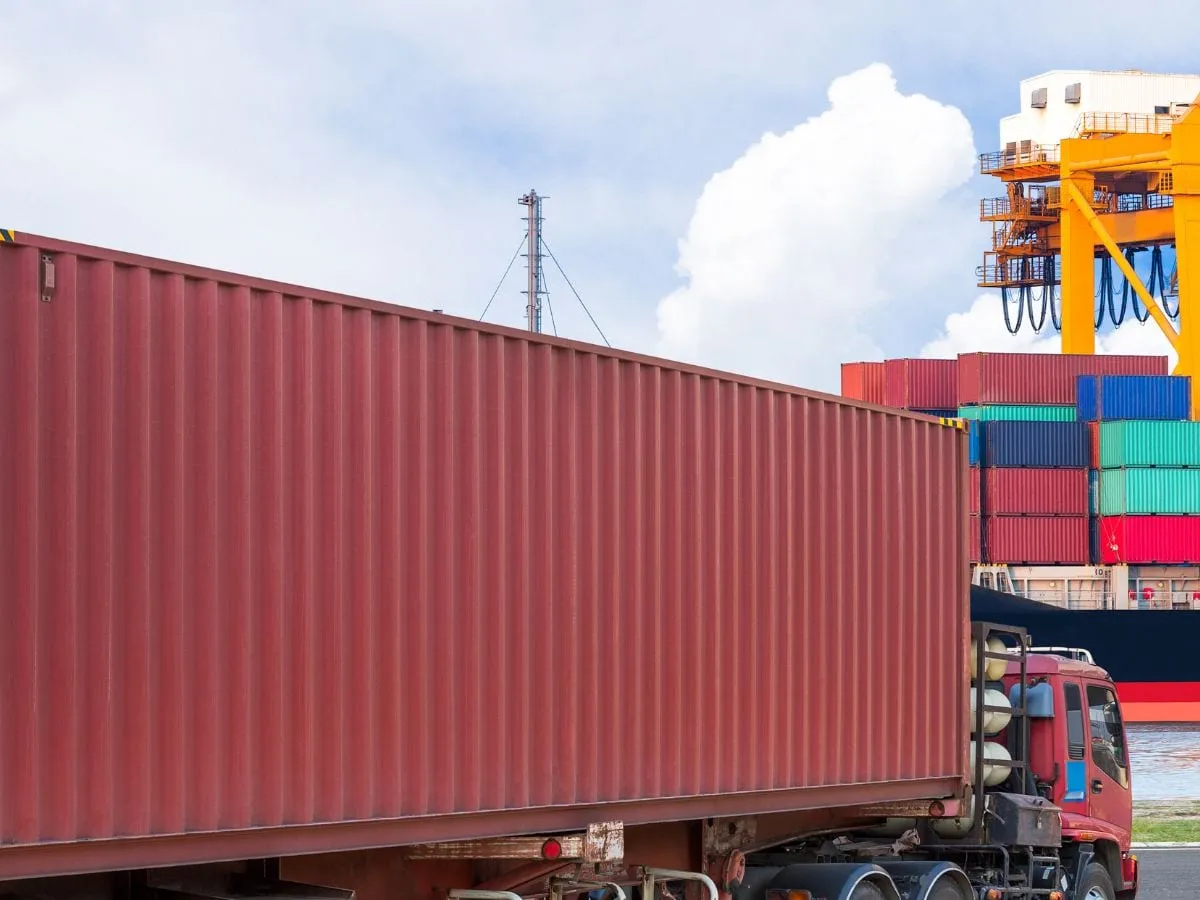 Camión con contenedor de cuarenta pies saliendo de una terminal portuaria